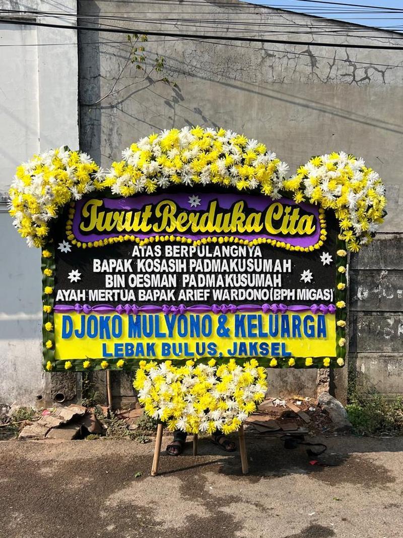 Papan bunga duka cita 4 titik hitam ungu dengan rangkaian krisan kuning putih di Karawang