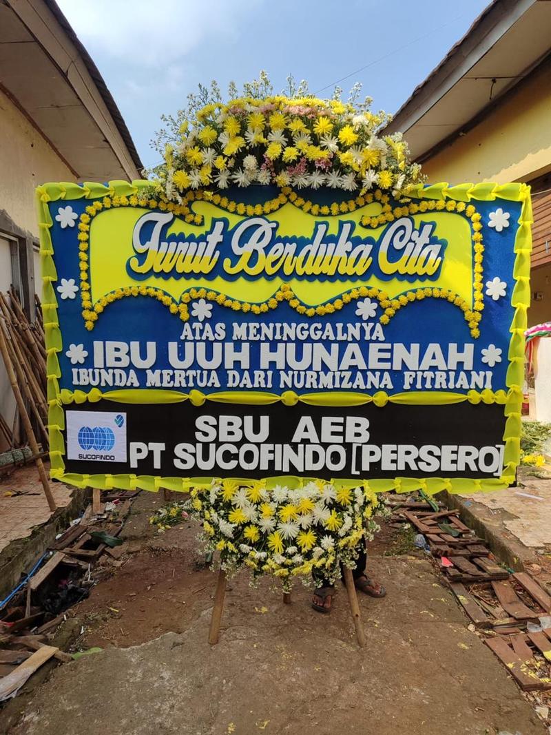 Papan bunga duka cita kuning biru dengan rangkaian krisan untuk pengiriman di Karawang